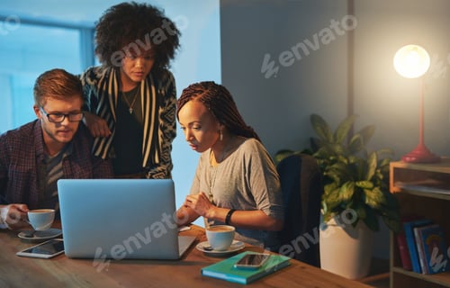 Preview: Cropped shot of a group of young people working late in the office