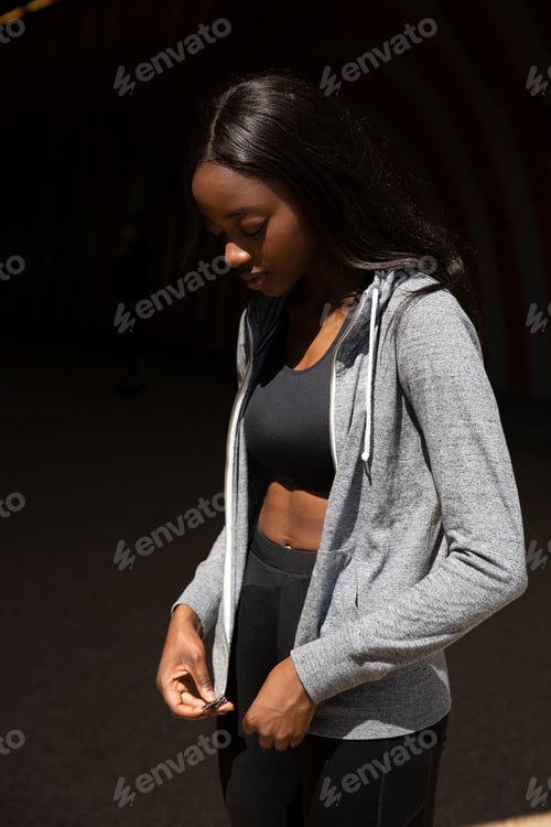 Preview: Young woman zipping hoodie