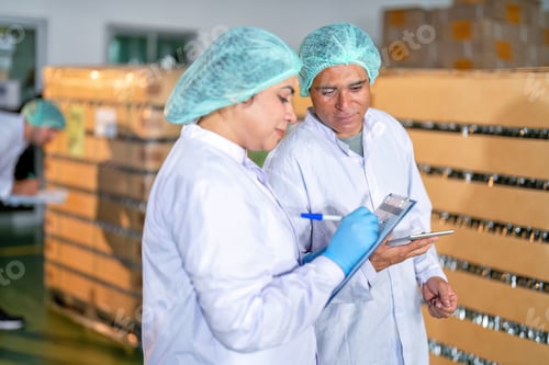 Preview: In warehouse quality control team checking drinking bottle stack on pallet before delivery