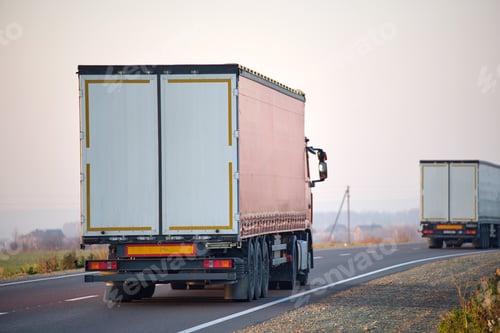 Preview: Semi-truck with cargo trailer driving on highway hauling goods in evening. Delivery transportation