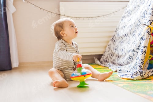 Preview: Cute baby boy toddler playing with toy indoors