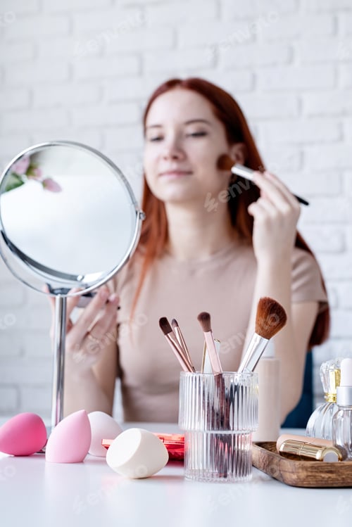 Preview: Woman Applying Makeup with Mirror and Brushes