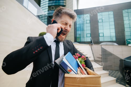 Preview: Frustrated businessman arguing on smartphone after job loss in city