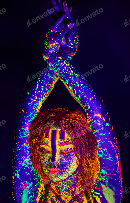 Preview: Neon goddess. Cropped shot of a young woman posing with neon paint on her face.