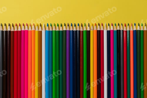 Preview: a row of set of colored pencils flat lay on pastel background