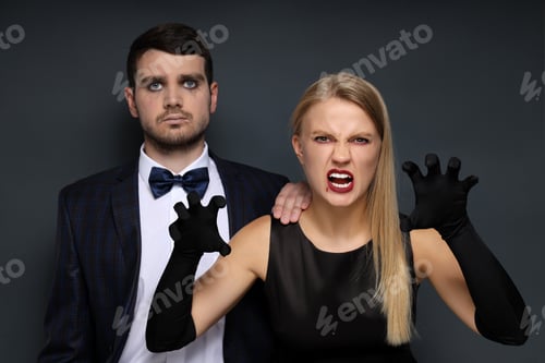 Preview: Concept of Halloween, young man and woman on dark background