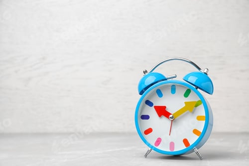 Preview: Alarm clock on table against light background. Time concept