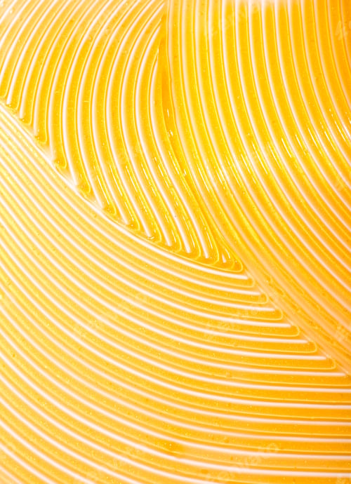 Preview: Vertical shot of a gold skincare slushed on a white background