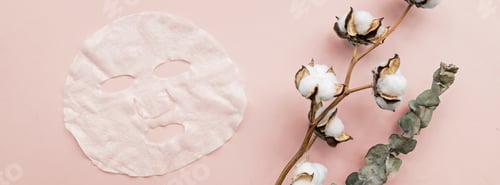 Preview: Horizontal banner for web design of face mask, eucalyptus and cotton flower on pink background