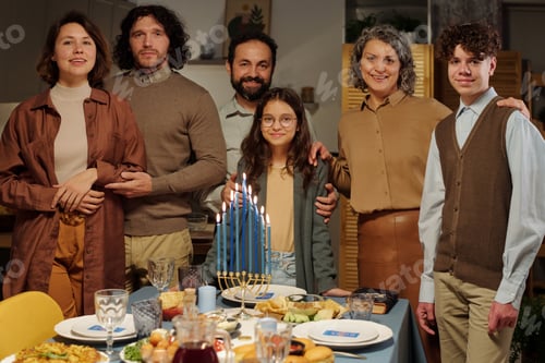 Preview: Family of six members of various generations standing by served table