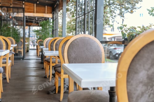 Preview: Elegant cafe terrace with wooden chairs and white tables for hospitality and dining concept