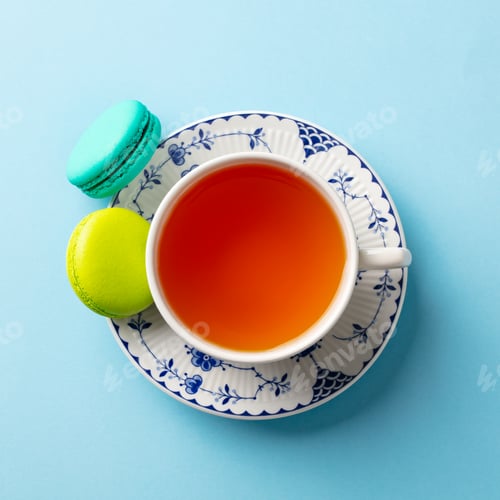 Preview: Macaroons Dessert and Cup of Tea on Blue Background. Top View. Close up.