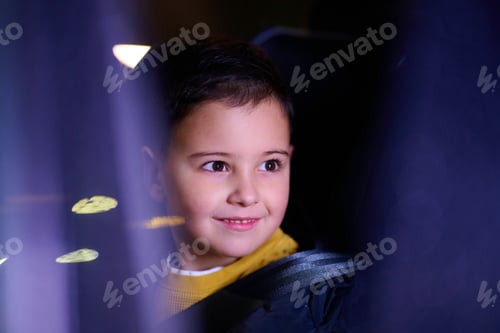 Preview: A young boy enjoys a car ride, captured through the window, as he observes the passing scenery.