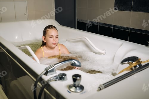 Preview: a little girl takes the procedure in a mineral bath. The patient receives water treatments with a