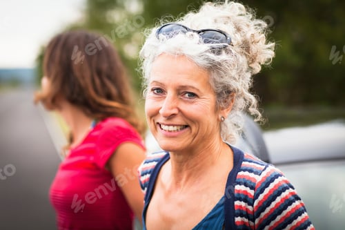 Preview: Smiling woman with sunglasses enjoying a summer day outdoors