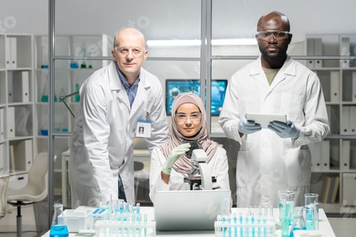 Preview: Three contemporary lab workers in protective eyeglasses, gloves and whitecoats