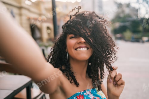 Preview: Afro american woman taking a selfie in the city.