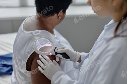 Preview: Middle Aged Black Woman Undergoing Skin Examination by Female Dermatologist