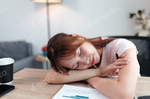 Preview: Young office worker sleeping at desk after working late