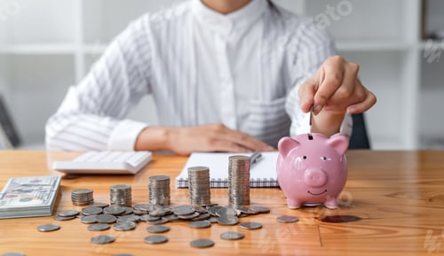 Preview: Businesswoman hand putting coin to pink piggy bank saving. Concept business, finance, money saving