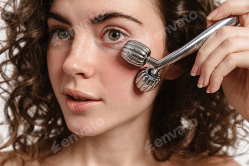 Preview: Beautiful shirtless curly girl using facial massager