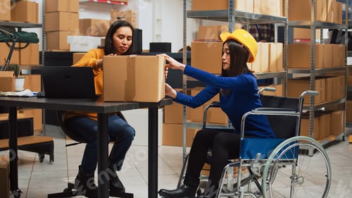 Preview: Asian woman in wheelchair carrying cardboard boxes