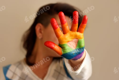Preview: Colorful painted hand of a woman with rainbow colors, pride