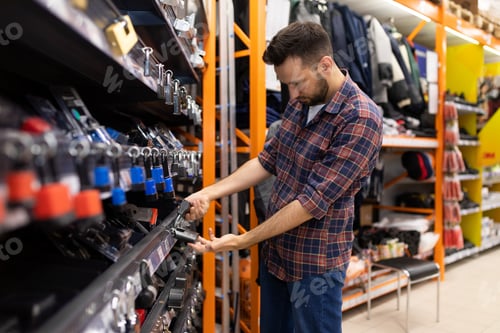 Preview: a man in a hardware store chooses a padlock