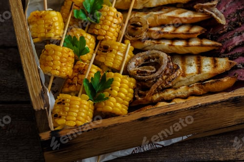 Preview: Close view of grilled corn and onion rings