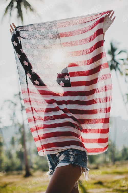 Preview: Young woman holding up American flag, Krabi, Thailand