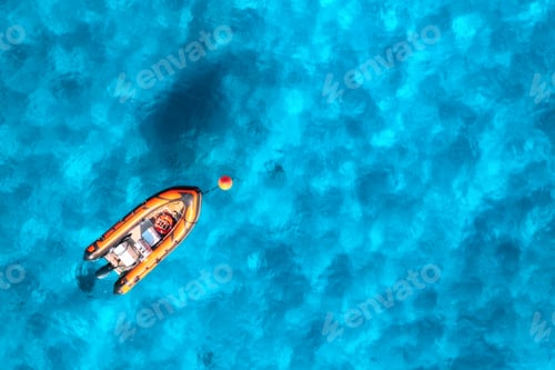 Preview: Aerial view of beautiful orange boat in blue sea at sunset