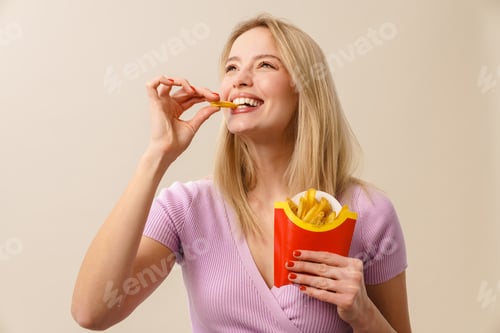 Preview: Cheerful beautiful girl laughing while eating french fries