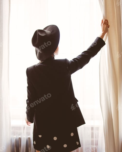 Preview: Young girl in black stay near window.