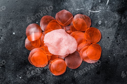 Preview: Raw kerupuk or prawn shrimp crackers, chips. Black background. Top view