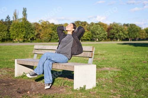 Preview: Portrait of happy asian girl feeling freedom and excitement, stretching hands while sitting on