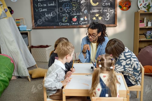Preview: Multiethnic Children Listening to Young Adult Man Teaching in Drawing Class
