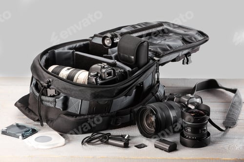 Preview: Professional photographer's equipment and backpack on light wooden table