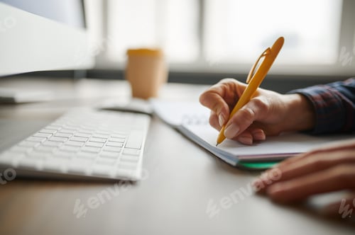 Preview: Female IT specialist writes in notepad in office