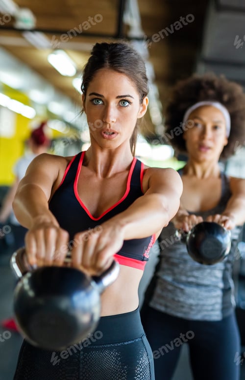 Preview: Group of fit people lifting dumbbells during an exercise class at the gym