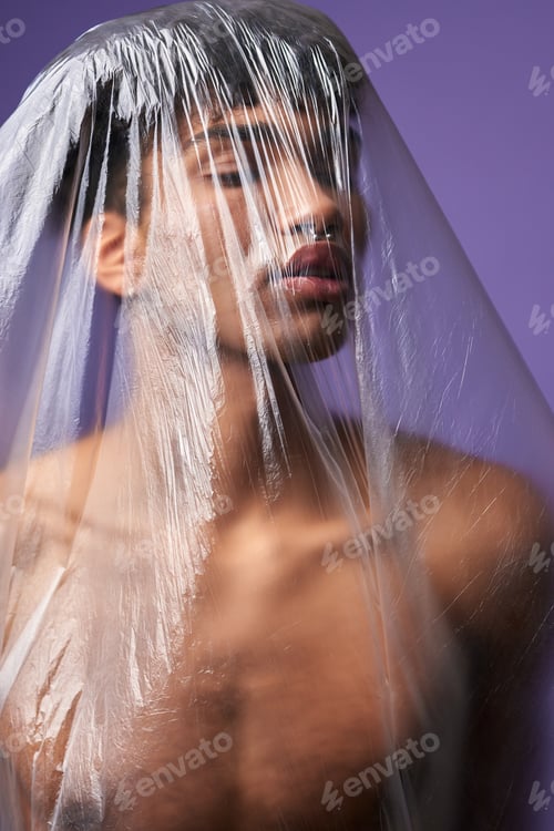 Preview: Young man with plastic bag on head with eyes closed portrait. Sensual transgender male stop