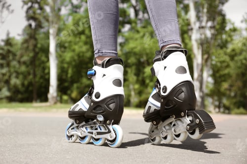 Preview: Woman with modern inline roller skates in city park, closeup