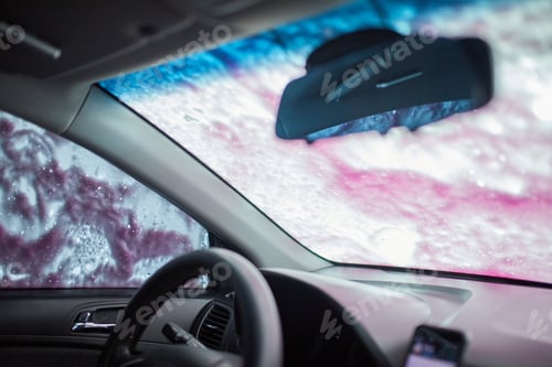 Preview: Man washing his car, using pink active foam on self service washing