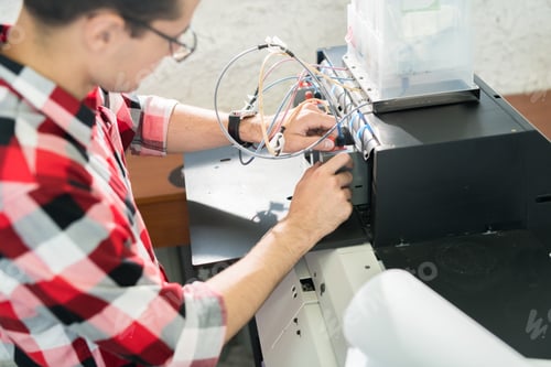 Preview: Man setting printing equipment