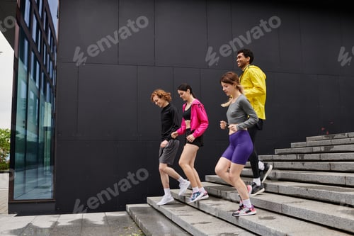 Preview: Group of young athletes enjoying a sporty moment while descending stairs in the city