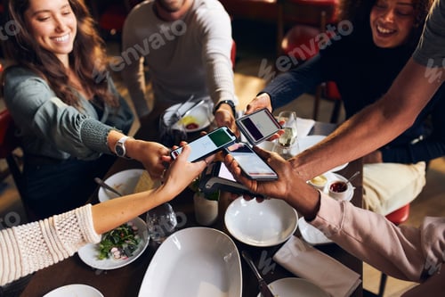 Preview: Friends splitting the bill in restaurant