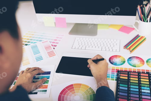 Preview: Rear view of creative designers working on desk using digital