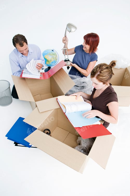 Preview: Business colleagues unpack office boxes