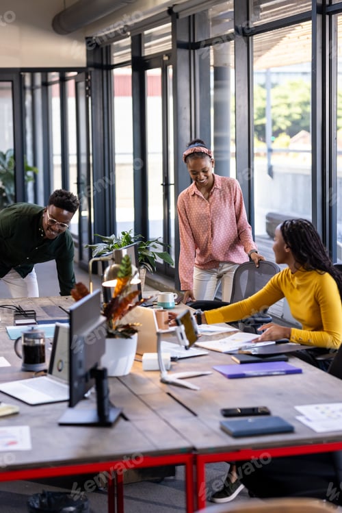 Preview: Collaborating in modern office, diverse team discussing project around table