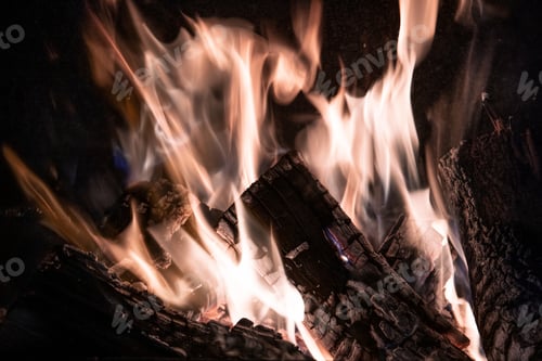 Preview: Fire orange tongues on black background in a brick fireplace