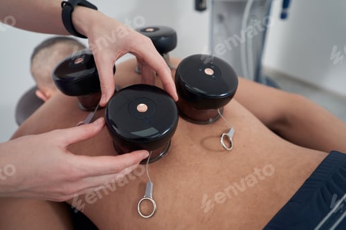 Preview: Man having vacuum therapy procedure in rehabilitation clinic